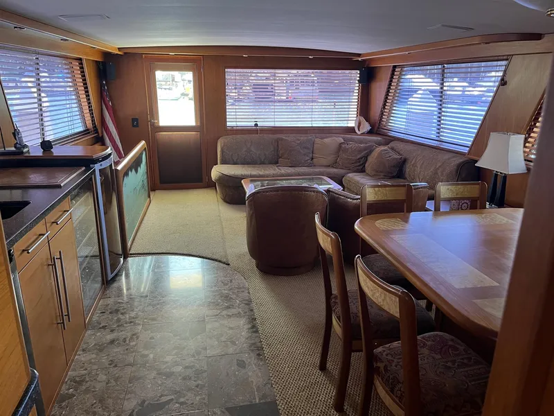 Slide: The Image of Interior of 1986 Hatteras 70' Cockpit Motor Yacht with spacious seating and dining area. - 17