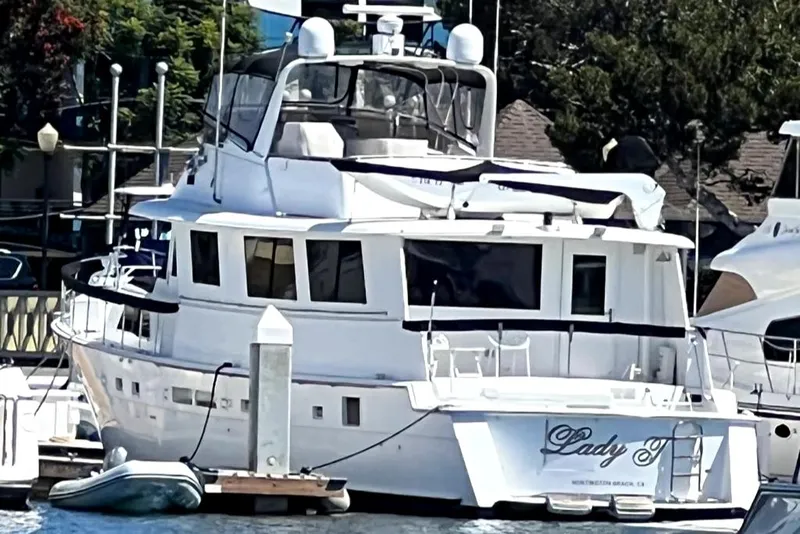 Slide: The Image of 1986 Hatteras 70' Cockpit Motor Yacht docked at a marina. - 2
