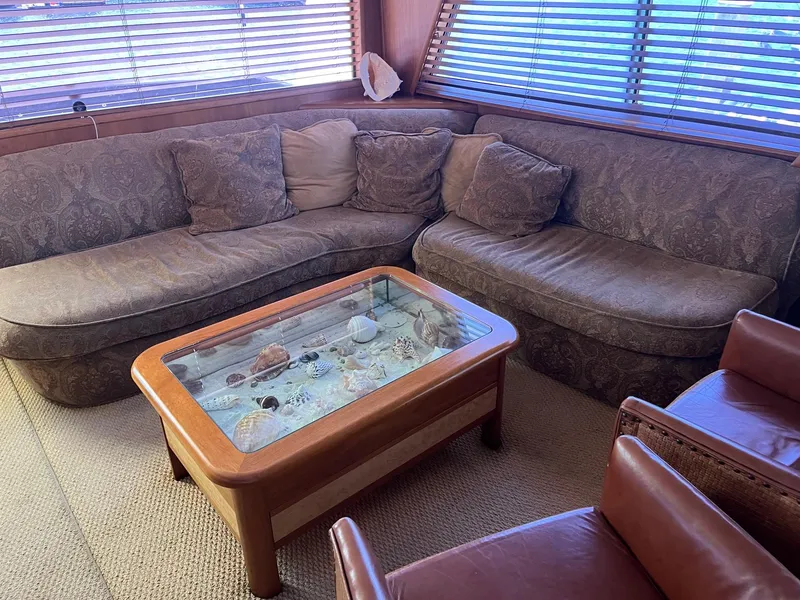 Slide: The Image of Cozy lounge area in 1986 Hatteras 70' Cockpit Motor Yacht with sectional sofa and glass-top coffee table. - 21