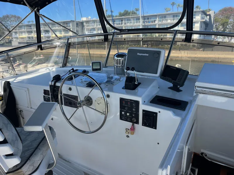 Slide: The Image of 1986 Hatteras 70' Cockpit Motor Yacht helm station with navigation equipment and steering wheel. - 29