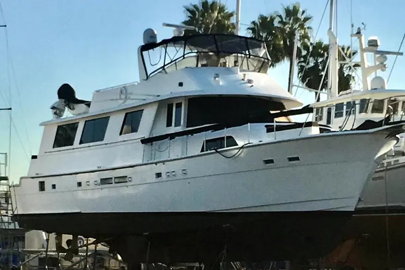 Slide: The Image of 1986 Hatteras 70' Cockpit Motor Yacht on dry dock with palm trees in background. - 3