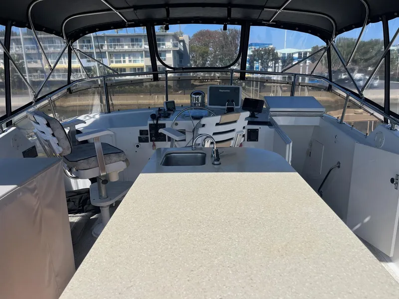Slide: The Image of 1986 Hatteras 70' Cockpit Motor Yacht helm with seating, sink, and navigation equipment. - 30