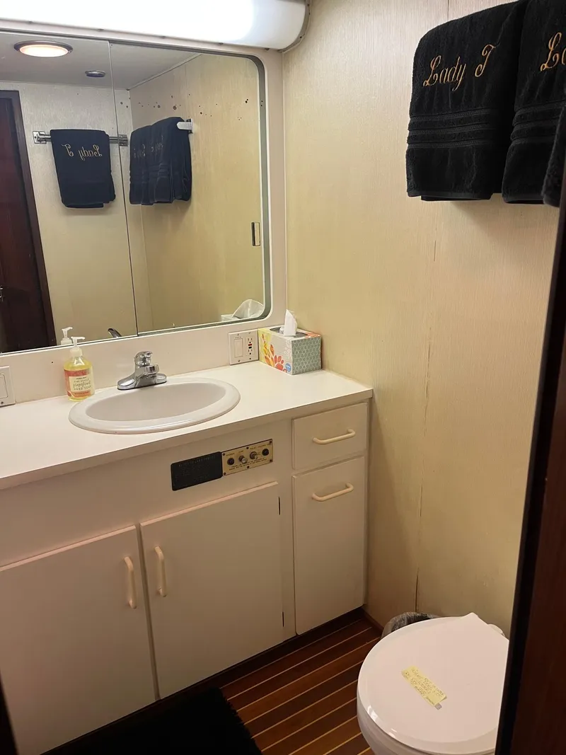 Slide: The Image of 1986 Hatteras 70' Cockpit Motor Yacht bathroom with sink, mirror, and toilet. - 44