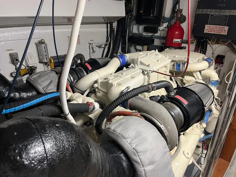 Slide: The Image of Engine room of a 1986 Hatteras 70' Cockpit Motor Yacht with visible machinery. - 49