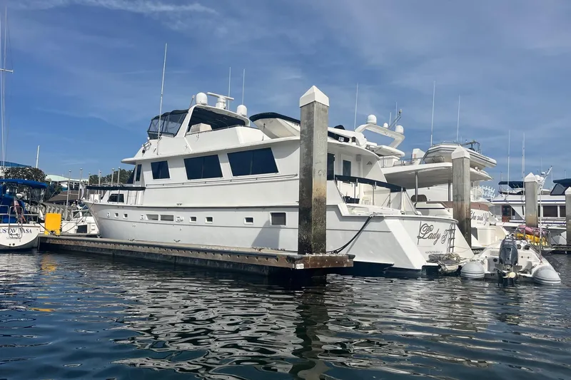 Slide: The Image of 1986 Hatteras 70 Cockpit Motor Yacht docked at marina under clear blue sky. - 55