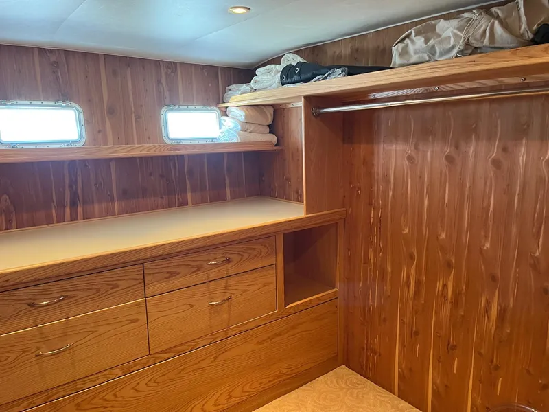 Slide: The Image of 1986 Hatteras 70' Cockpit Motor Yacht interior with wooden cabinetry and storage space. - 9