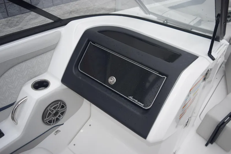 Slide: The Image of 2024 Hurricane SunDeck 2600 OB boat dashboard with storage compartment and speaker. - 15