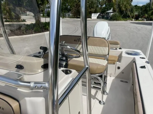 Slide: The Image of 2023 Sea Chaser 22 HFC boat with tan seating in marina. - 12