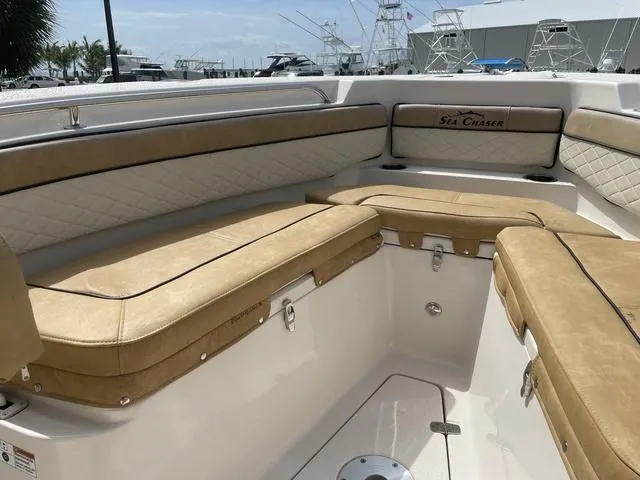 Slide: The Image of 2023 Sea Chaser 22 HFC boat with Suzuki outboard motor, beige seating, and fishing rod holders. - 14