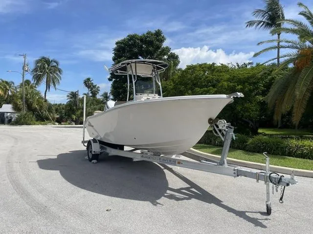 Slide: The Image of 2023 Sea Chaser 22 HFC boat on a trailer in a sunny, tree-lined area. - 7