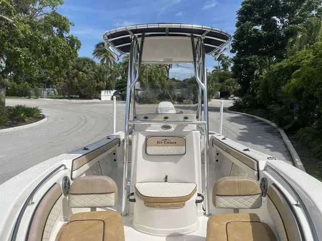 Slide: The Image of 2023 Sea Chaser 22 HFC boat on a trailer, parked outdoors with palm trees. - 9