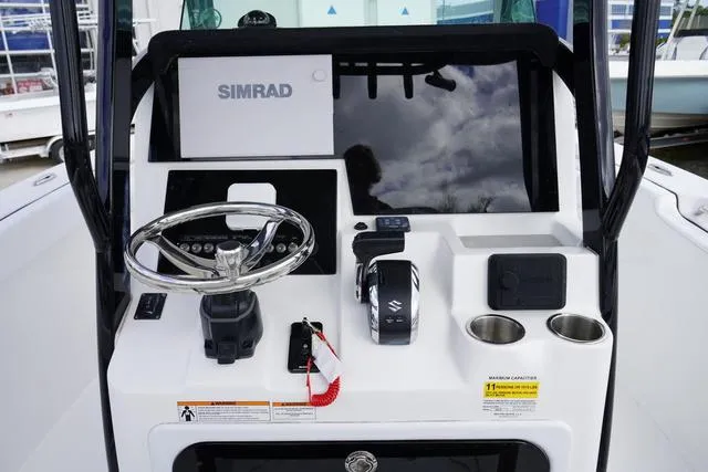 Slide: The Image of 2024 Sea Pro 242 DLX boat console with Simrad electronics and Suzuki throttle. - 13