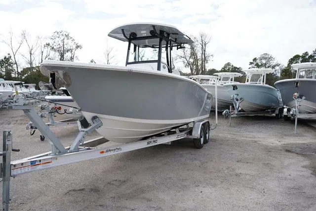 Slide: The Image of 2024 Sea Pro 242 DLX boat on a trailer in a boatyard. - 2