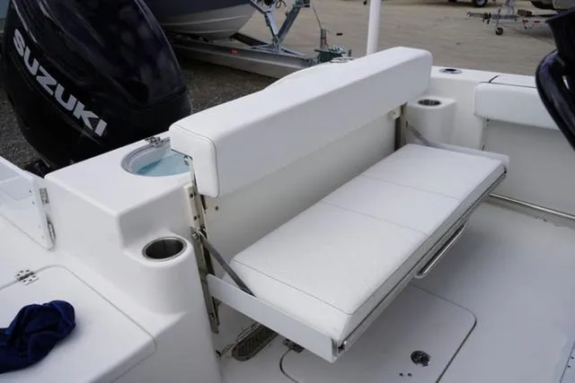 Slide: The Image of 2024 Sea Pro 242 DLX boat with white cushioned seating and Suzuki outboard motor. - 30