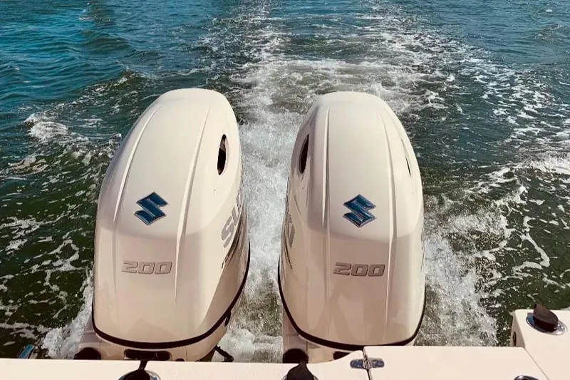 Slide: The Image of Twin Suzuki outboard engines on a 2019 Sea Chaser 27 HFC boat in motion. - 11