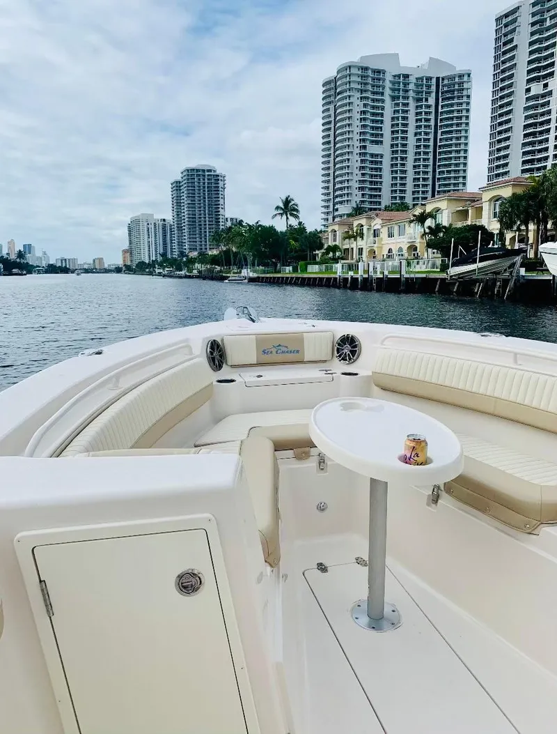 Slide: The Image of 2019 Sea Chaser 27 HFC boat on waterway, city skyline in background. - 7