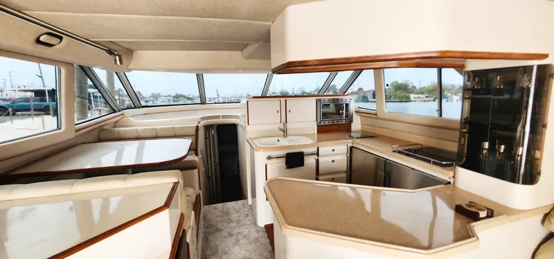 Slide: The Image of Interior of 1997 Sea Ray 550 Sedan Bridge yacht with kitchen and dining area. - 16