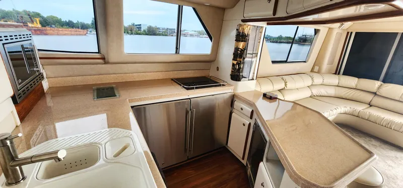 Slide: The Image of Luxurious kitchen and lounge area inside a 1997 Sea Ray 550 Sedan Bridge yacht. - 18