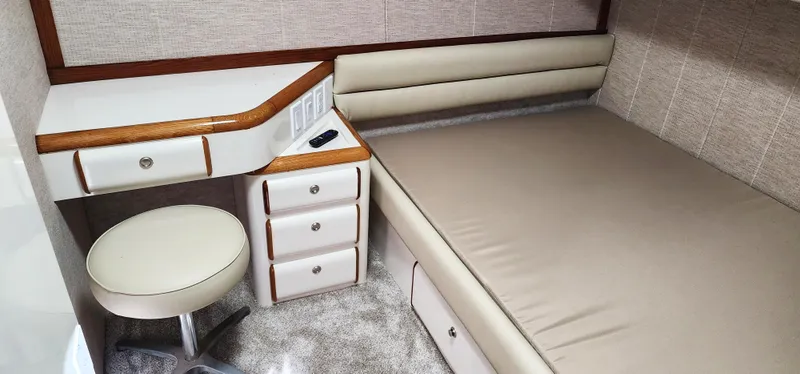 Slide: The Image of 1997 Sea Ray 550 Sedan Bridge cabin interior with bed, desk, and stool. - 21