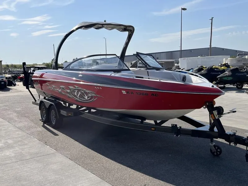 Slide: The Image of 2006 Malibu 23 LSV red boat on trailer in outdoor lot. - 1