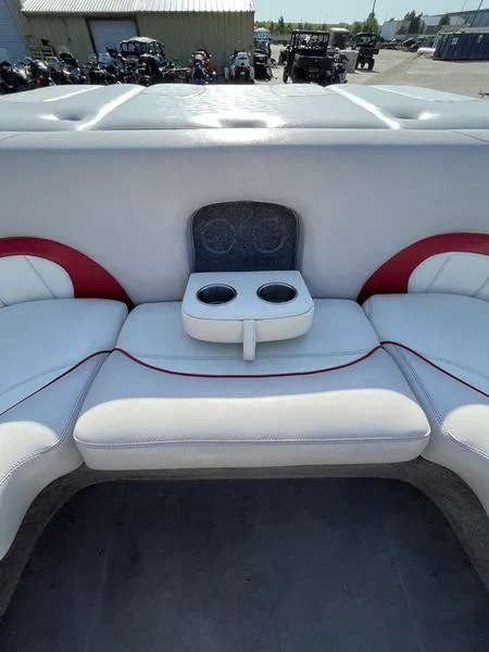 Slide: The Image of 2006 Malibu 23 LSV boat interior with white and red seating and cup holders. - 10