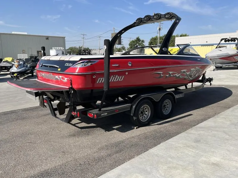 Slide: The Image of 2006 Malibu 23 LSV red boat on trailer in parking lot. - 4