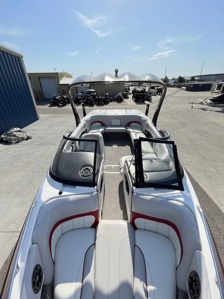 Slide: The Image of 2006 Malibu 23 LSV boat with white and red interior, docked outdoors. - 6