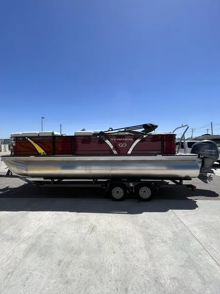 Slide: The Image of 2023 Veranda VP22RFL pontoon boat with red exterior on a trailer. - 2