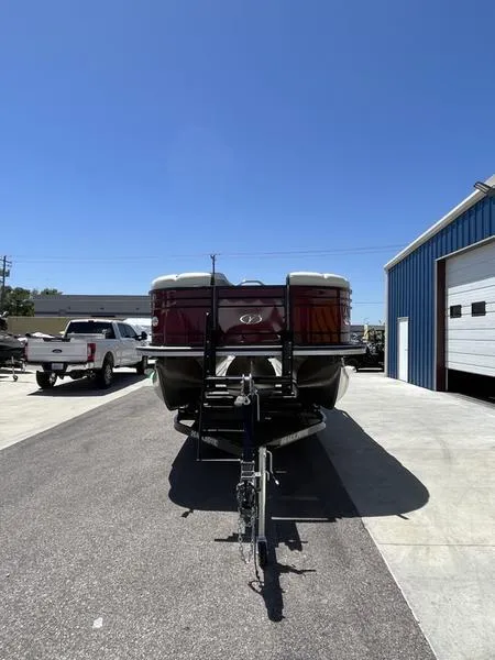 Slide: The Image of 2023 Veranda VP22RFL pontoon boat on trailer outside a blue warehouse. - 5