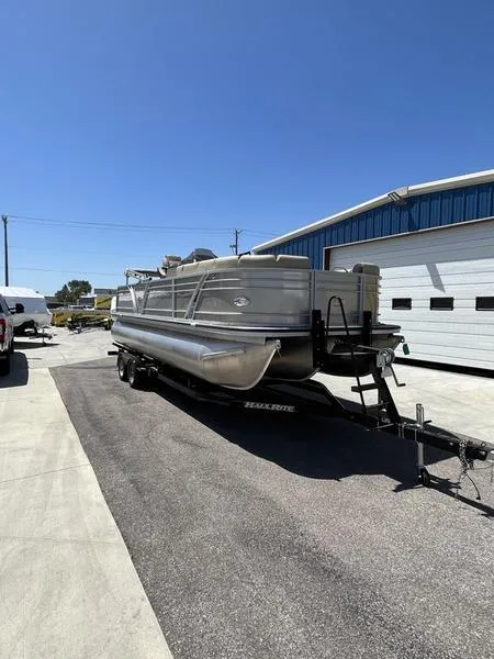 Slide: The Image of 2023 Veranda VP22VLB pontoon boat on a trailer outside a warehouse. - 2