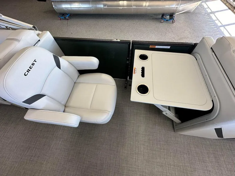 Slide: The Image of 2024 Crest Classic LX 220 SLC CPT boat interior with seating and table. - 5