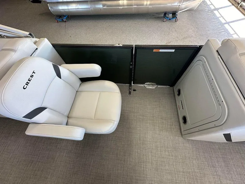 Slide: The Image of 2024 Crest Classic LX 220 SLC CPT boat interior with plush seating and storage compartment. - 6