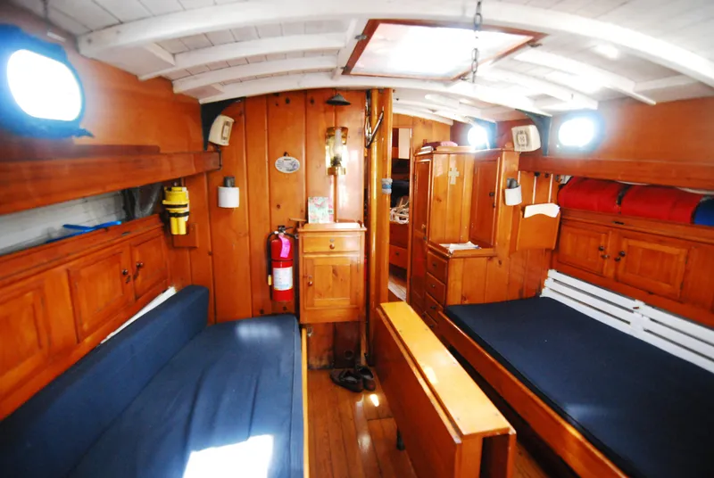 Slide: The Image of Interior of a 1939 Concordia Motorsailer with wooden furnishings and blue seating. - 12