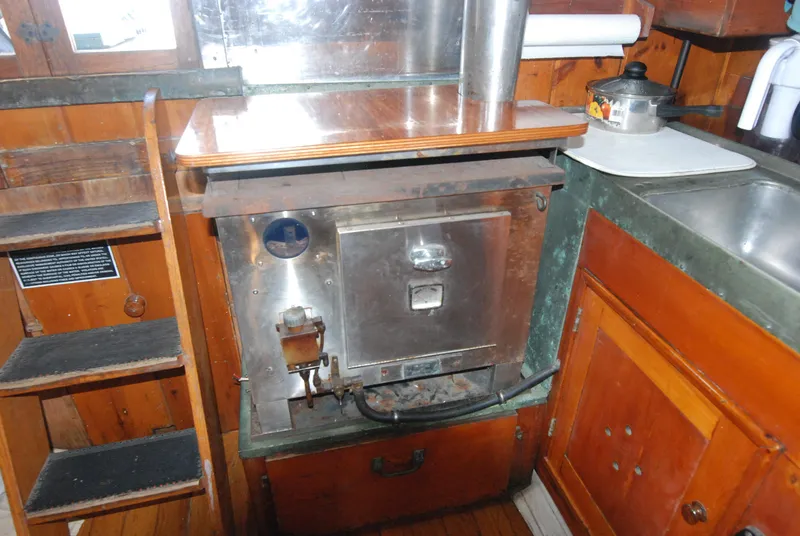 Slide: The Image of 1939 Concordia Motorsailer galley with vintage stove and wooden cabinetry. - 16