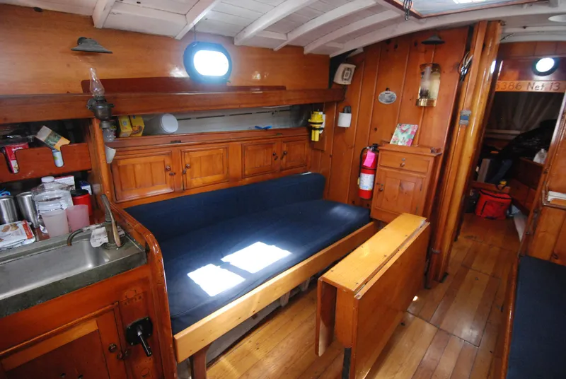 Slide: The Image of Interior of a 1939 Concordia Motorsailer, featuring wooden furnishings and a cozy seating area. - 8
