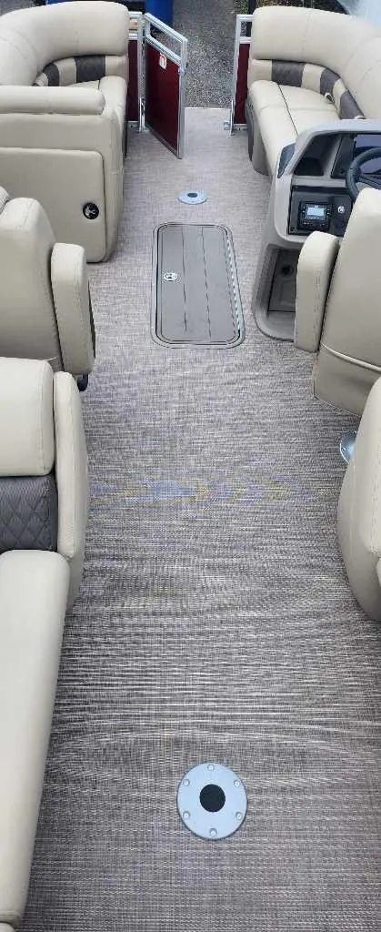 Slide: The Image of 2024 Sun Tracker Party Barge 22 RF XP3 interior with beige seating and carpeted floor. - 10