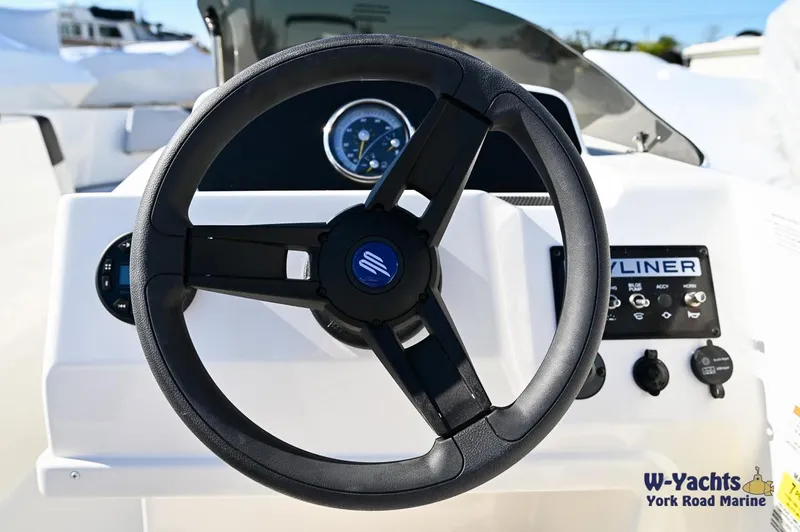 Slide: The Image of 2024 Bayliner M17 boat steering wheel and dashboard controls. - 17