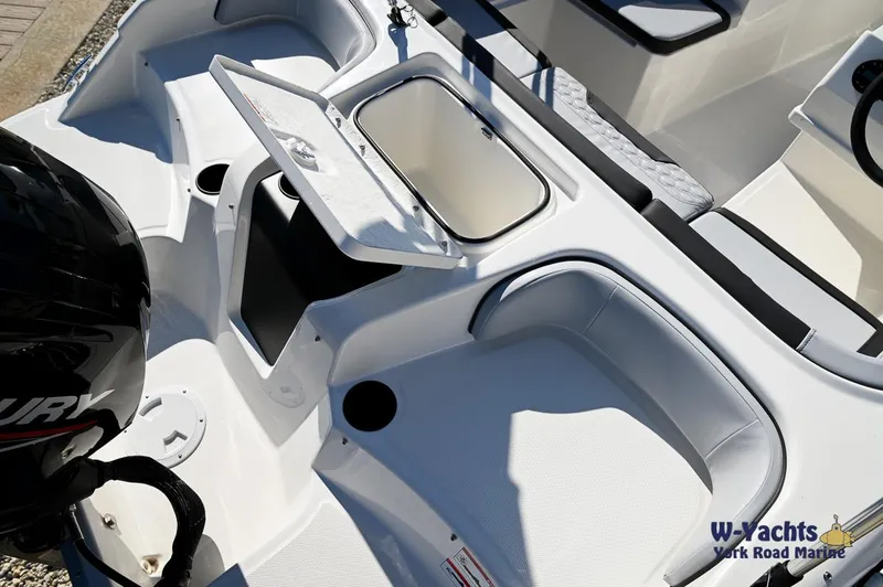 Slide: The Image of 2024 Bayliner M17 boat interior with open storage compartment and Mercury engine. - 22