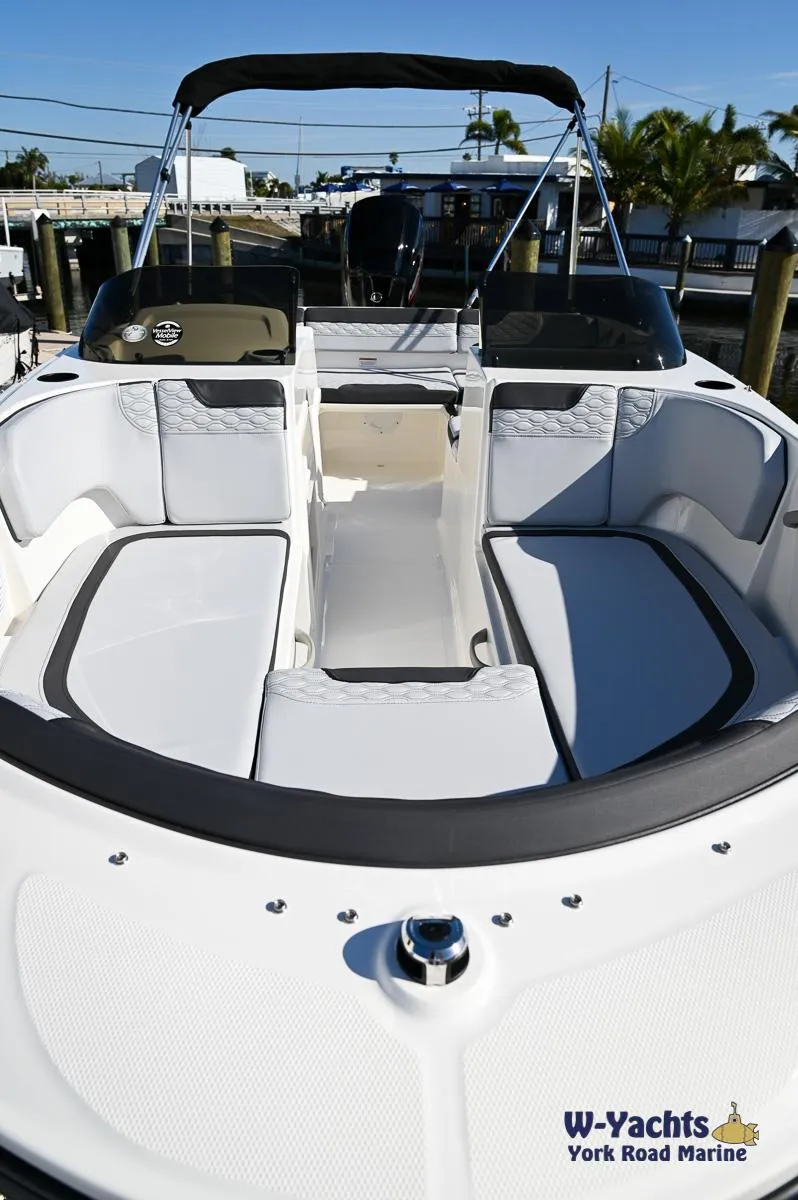 Slide: The Image of 2024 Bayliner M17 boat interior with seating and canopy, docked at marina. - 5