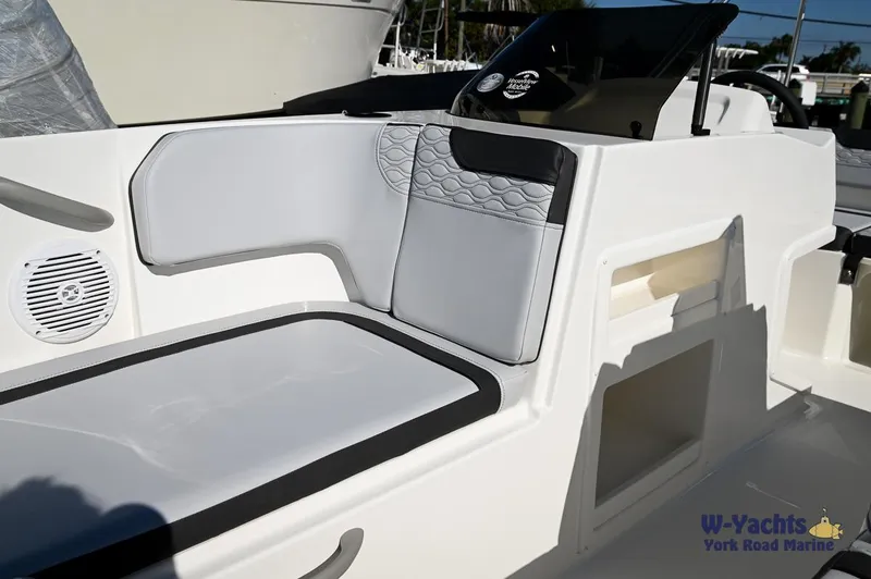 Slide: The Image of 2024 Bayliner M17 boat interior with cushioned seating and storage compartments. - 9