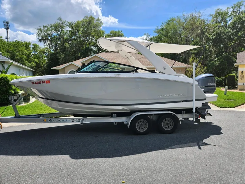 Slide: The Image of 2021 Regal 23 OBX boat on trailer in residential area. - 0
