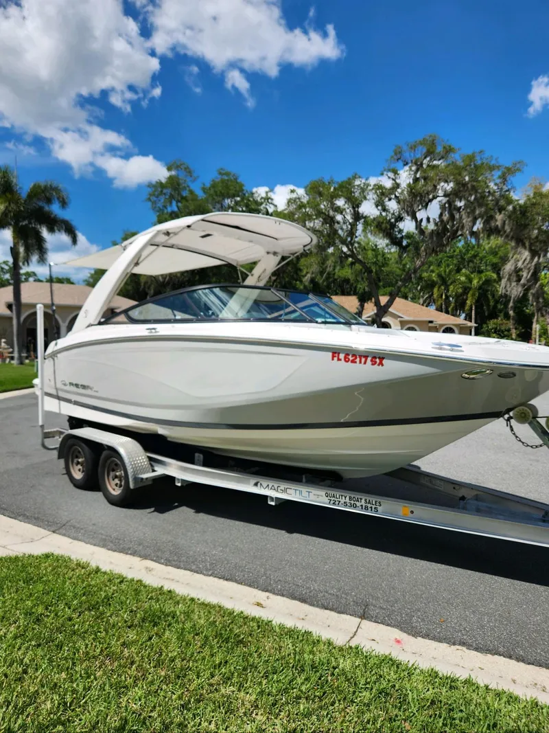 Slide: The Image of 2021 Regal 23 OBX boat on a trailer, parked on a sunny street. - 10