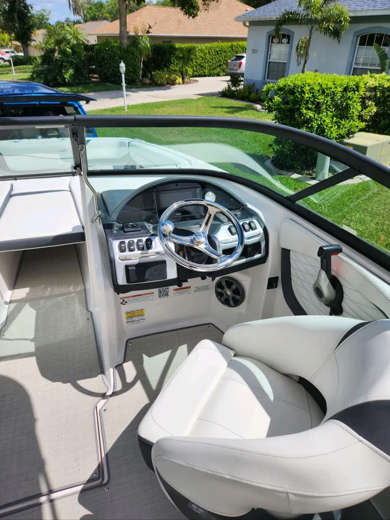 Slide: The Image of 2021 Regal 23 OBX boat cockpit with steering wheel and captain's chair. - 13