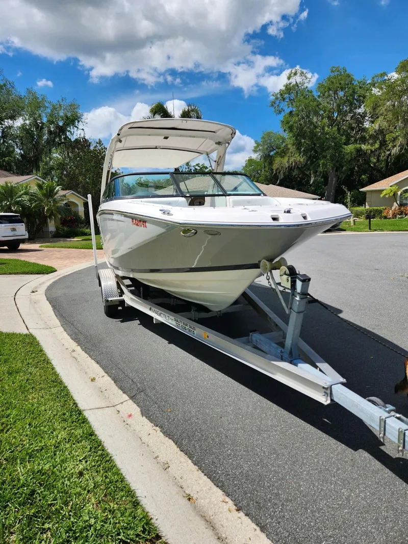 Slide: The Image of 2021 Regal 23 OBX boat on a trailer in a suburban neighborhood. - 9