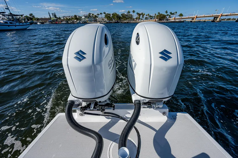 Slide: The Image of Twin Suzuki outboard motors on a 2023 Dusky 27cc boat, cruising on open water. - 10