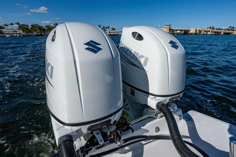 Slide: The Image of Twin Suzuki outboard motors on a 2023 Dusky 27cc boat, cruising on a sunny day. - 11