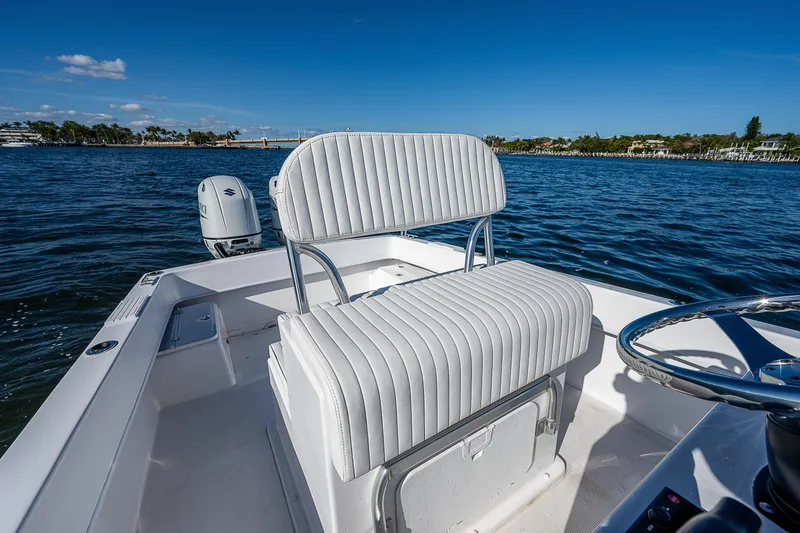 Slide: The Image of 2023 Dusky 27cc boat interior with white seating on a sunny day. - 16