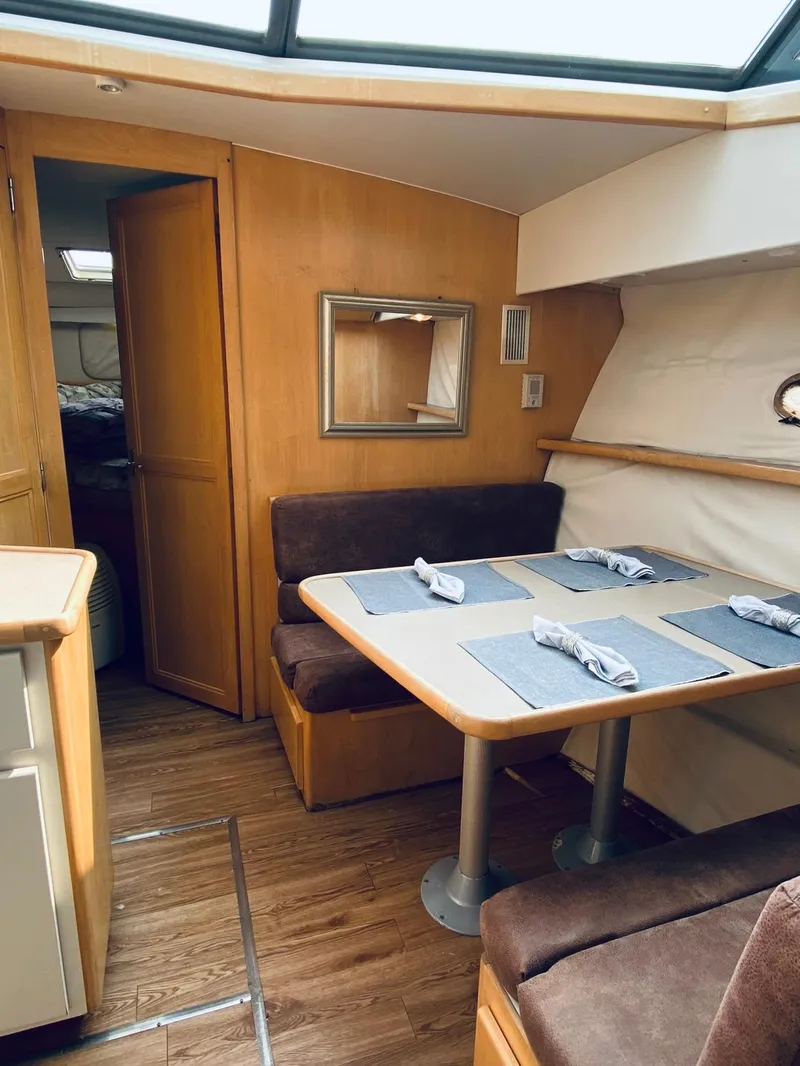 Slide: The Image of 1994 Carver 430 Cockpit Motor Yacht interior with dining area and wooden furnishings. - 13
