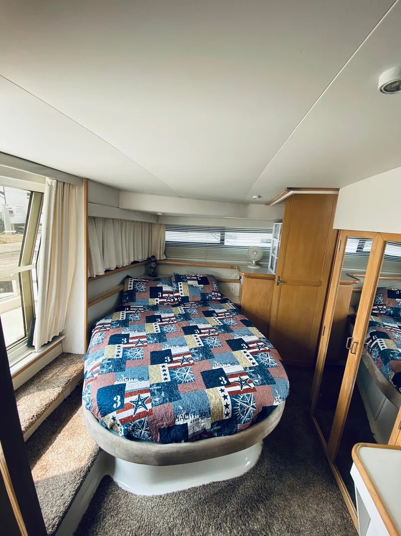 Slide: The Image of Cozy bedroom in 1994 Carver 430 Cockpit Motor Yacht with colorful quilt and wooden cabinetry. - 14