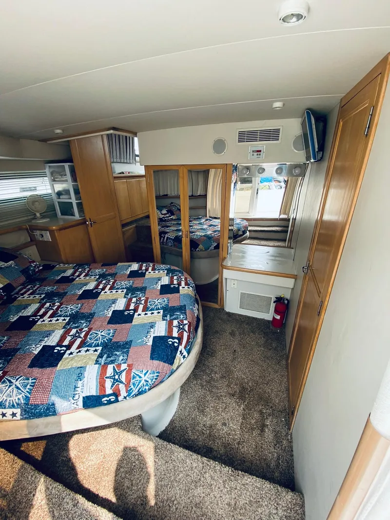 Slide: The Image of Interior of 1994 Carver 430 Cockpit Motor Yacht with cozy bedroom and patterned bedding. - 15